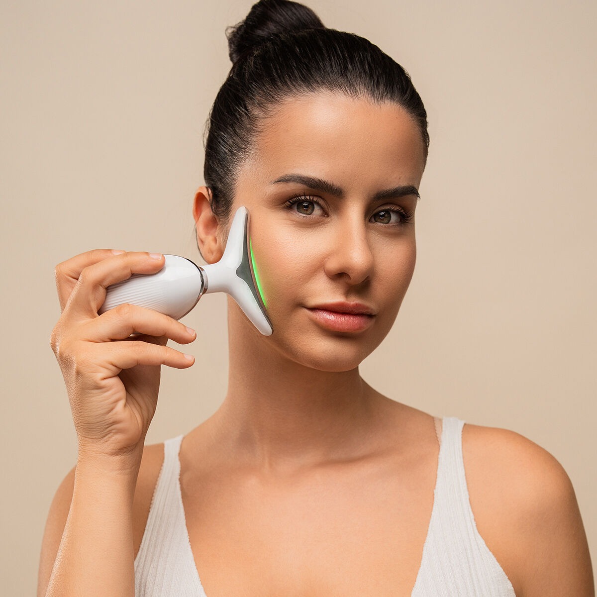 Femme utilisant l'appareil de soin Thalvina LED EMS sur le visage
